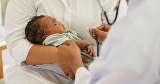mother holding newborn in doctor's office
