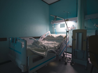 empty hospital bed in a room with blue walls