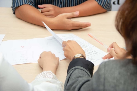 three people looking over papers