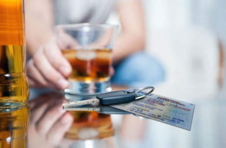 car key sitting next to an alcoholic beverage