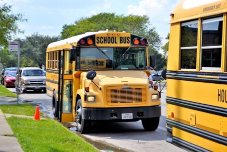 Schoolbuses pullingup to the curb