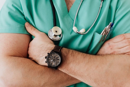 chest level image of a medical practitioner in green scrubs