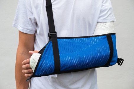 person with their arm casted and in a blue sling