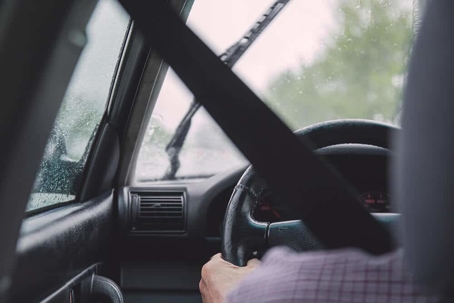 inside of a car with seatbelt and steering wheel