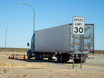 semi truck pulled over on the side of the road with a 30 MPH speed limit sign behind it
