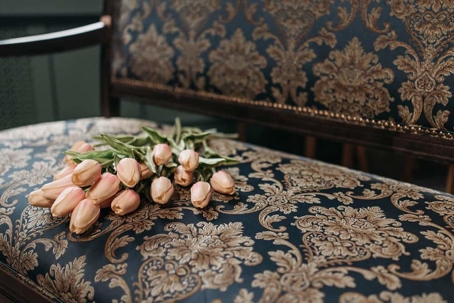 pink tulips laying on a patterned chair
