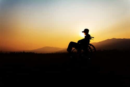 silhouette of a person in a wheelchair at sunset.