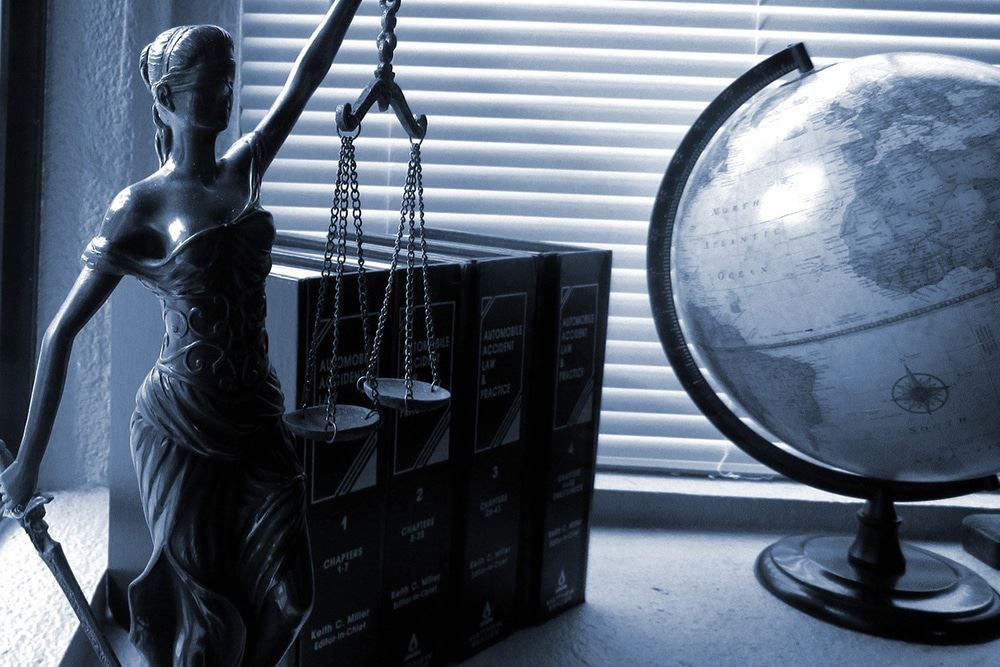 Lady Justice next to books and a globe